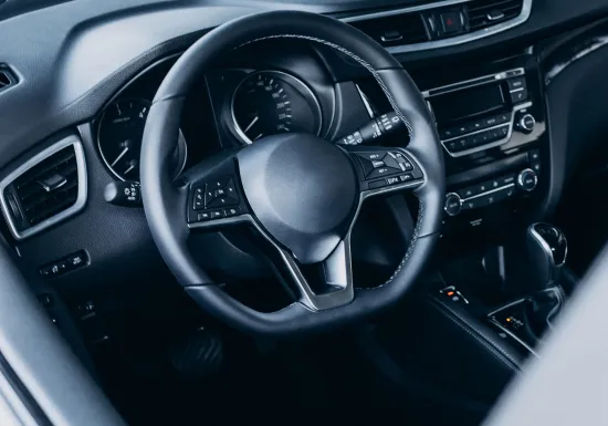 View of a vehicle interior with close-ups of a dashboard, steering wheel and centre console made using technical thermoplastic materials.